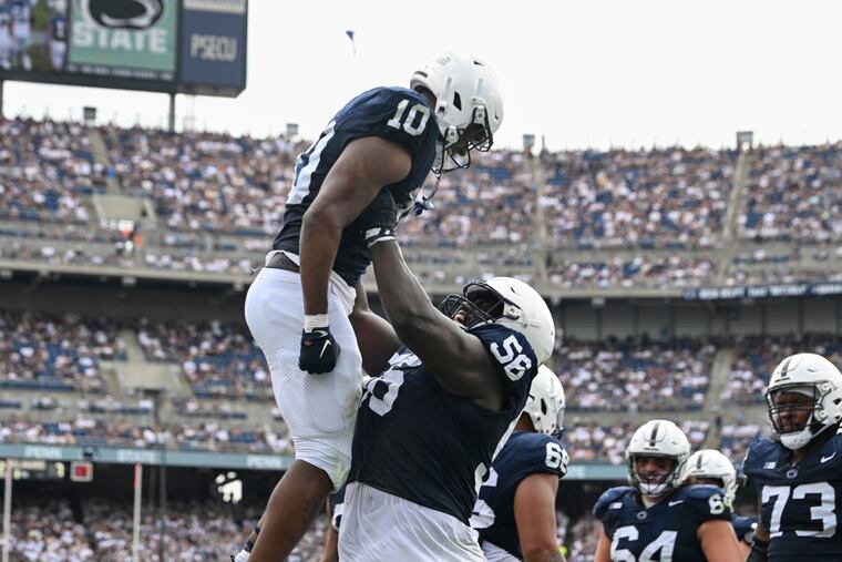 Penn State running back Nicholas Singleton celebrates a touchdown with offensive lineman JB Nelson (56) during the first half against Delaware.
