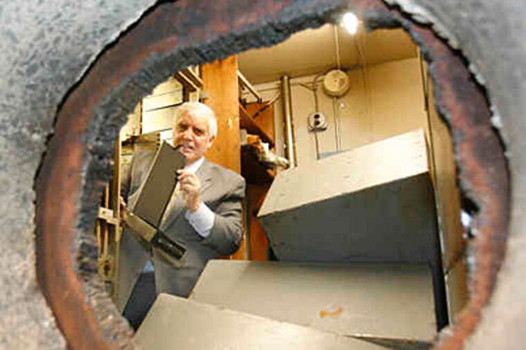 Burlington County College's Robert Messina checks one of the newly revealed safe-deposit boxes. (Charles Fox / Staff)