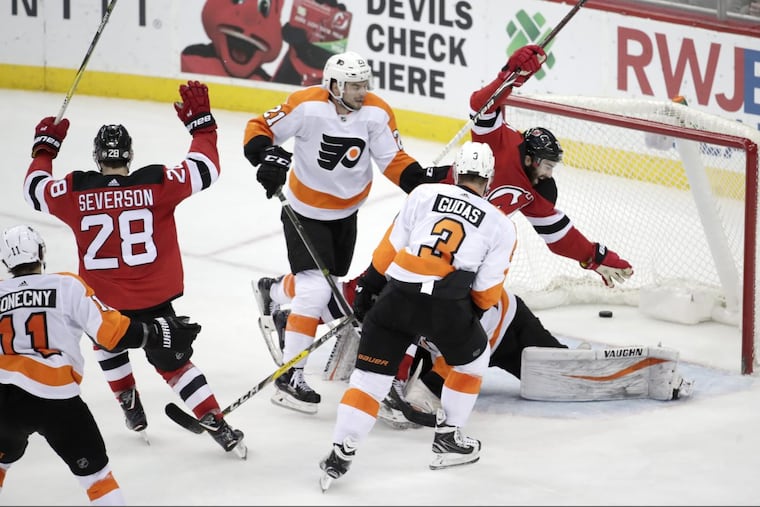 New Jersey Devils defenseman Damon Severson (28) celebrates with teammate right wing Kyle Palmieri, right, after scoring against the Flyers in their 4-3 win.
