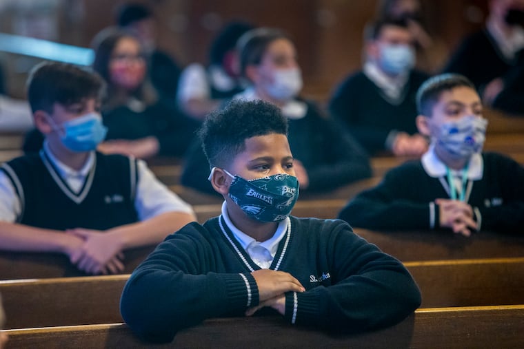Students from St. Martha Parish School wear their masks and social distance during Ash Wednesday mass in February.