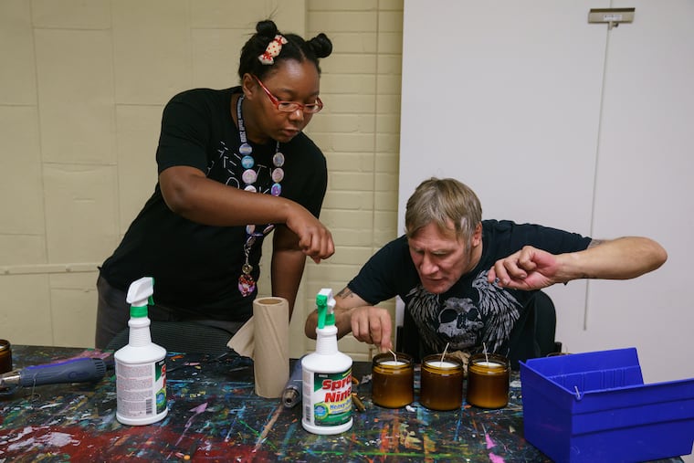 Kai Oceans (left), workshop facilitator, and Sean Toal, a resident, make candles as part of a gift box business that brings money to Project HOME.