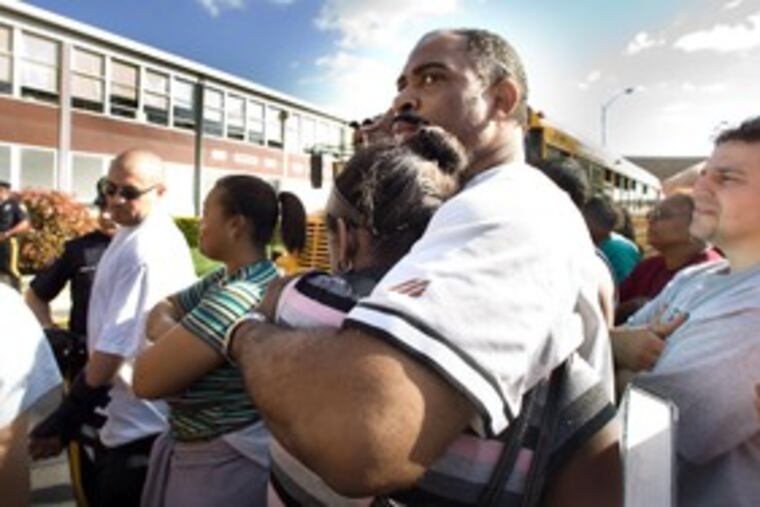 Patrick May embraces his daughter Akria, 15, after she was among students slowly allowed to leave the Winslow High building.