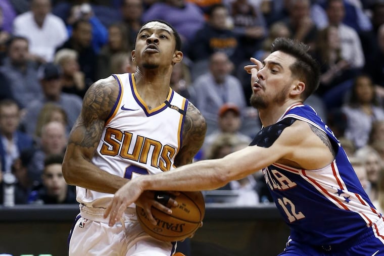 Philadelphia 76ers guard T.J. McConnell (12) strips Phoenix Suns guard Tyler Ulis, left, of the ball during the second half of an NBA basketball game Sunday, Dec. 31, 2017, in Phoenix. The 76ers defeated the Suns 123-110.