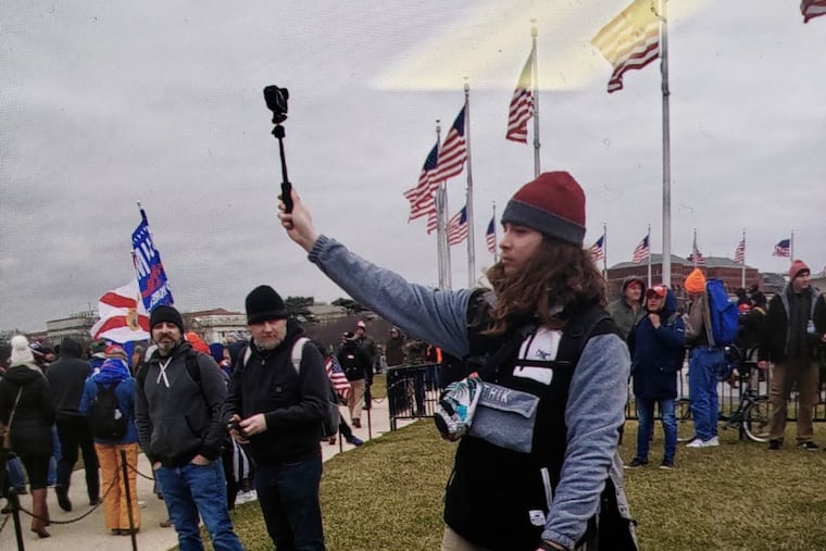 A man prosecutors have identified as James Rahm III, of Atlantic City, films the crowd outside the U.S. Capitol in Washington on Jan. 6, 2021.