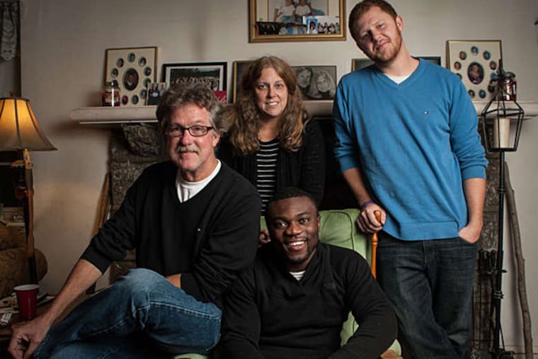 John Sneh, 24 (center), made his adoptive family proud when he graduated last week from La Salle with a bachelor's in marketing and a minor in communications. In a Ballough family portrait are (from left) Gerry, Daryl, and Denny. Absent is older brother Dorian. (MATTHEW HALL / Staff Photographer)