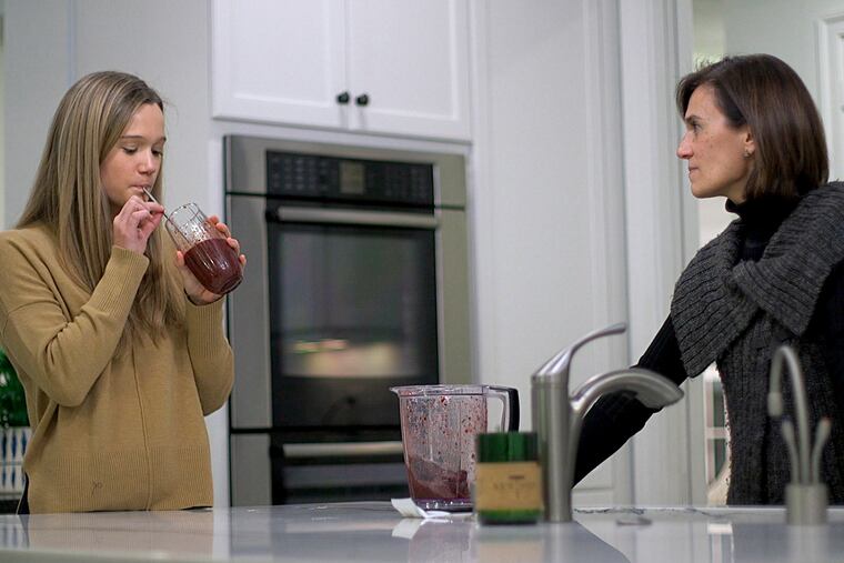 Nina Nichols, 18, takes her daily dose of Palforzia as her mother, Maria Acebal watches, in her home in Washington.