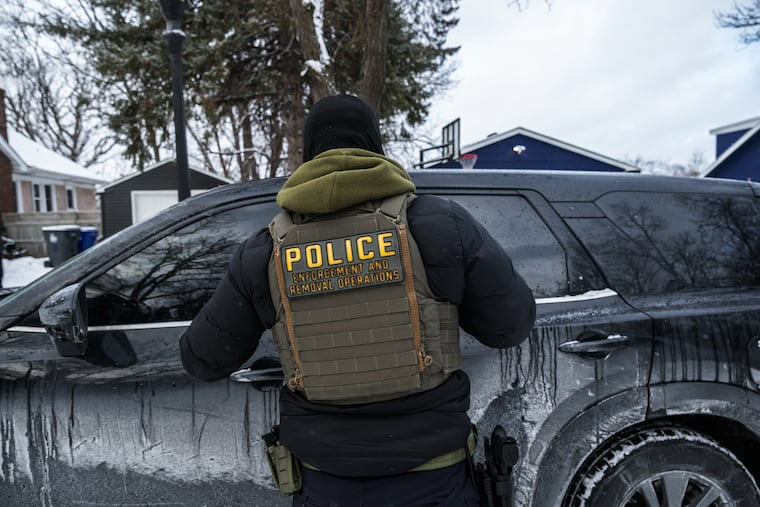 An ICE agent outside a private residence in St. Paul, Minn, in January 2026. On the street operations are increasingly being supplemented by database searches.