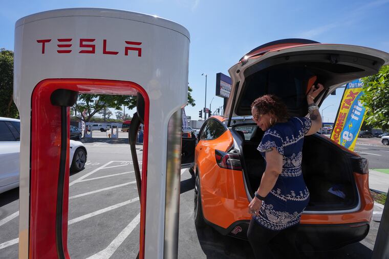 Janelle Lowe prepares to charge her electric vehicle at a Tesla charging station May 22, 2025, in Long Beach, Calif. Experts say there are still strong financial reasons to consider buying an EV even without federal tax incentives.