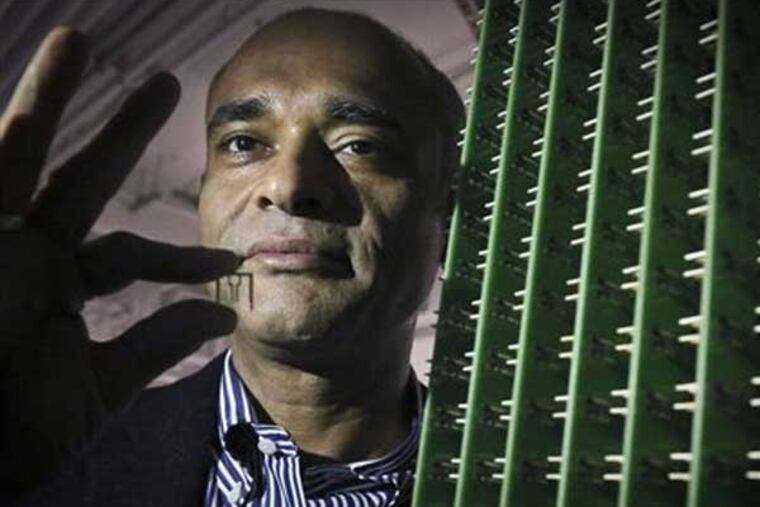 In this Thursday, Dec. 20, 2012, photo, Chet Kanojia, founder and CEO of Aereo, Inc., stands next to a server array of antennas as he holds an antenna between his fingers, in New York. Aereo is one of several startups created to deliver traditional media over the Internet without licensing agreements. Past efforts have typically been rejected by courts as copyright violations. In Aereo’s case, the judge accepted the company’s legal reasoning, but with reluctance. (AP Photo/Bebeto Matthews)