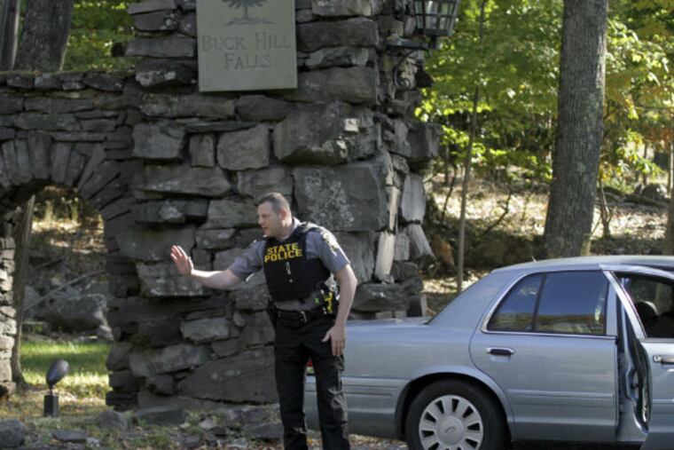 Pennsylvania State Police officers block the entrance to Buck Hill Falls in Barrett Township, Pa, where the search for Eric Frein continues. Frein is suspected of fatally shooting a state trooper and wounding another at the Blooming Grove state police barracks two weeks ago. (AP Photo/Scranton Times & Tribune, Michael J. Mullen)