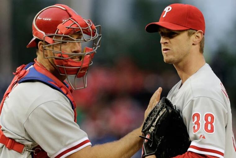 Erik Kratz (left) pats starting pitcher Kyle Kendrick (38) on the chest as he departs the mound after talking during the second inning of a baseball game against the Washington Nationals at Nationals Park,Friday, May 24, 2013, in Washington. (Alex Brandon/AP)