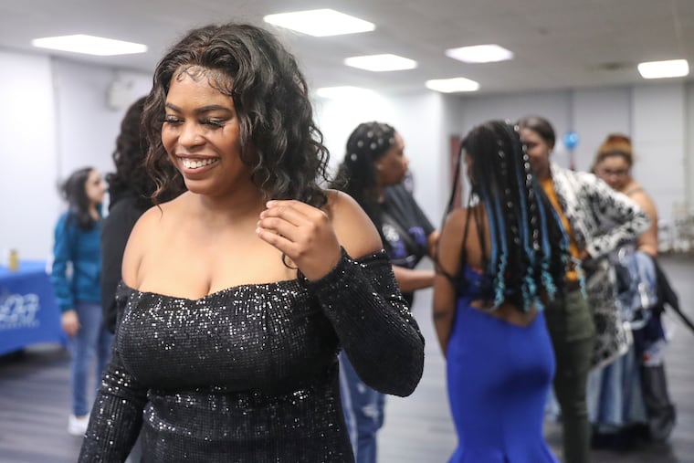 Karlice Williams smiles while trying on a prom gown at Promenade Reception Hall in Philadelphia on Wednesday, April 26, 2023. High school students who attend the event shopped for free prom gowns that were donated.