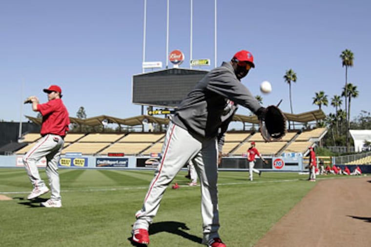 Ryan Howard catches a few during practice Tuesday at Dodger Stadium for Game 5 of the NLCS tonight. While happy with their 3-1 lead, the Phils won't be satisfied just making their first World Series in 15 years. (Michael Perez / Staff Photographer)
