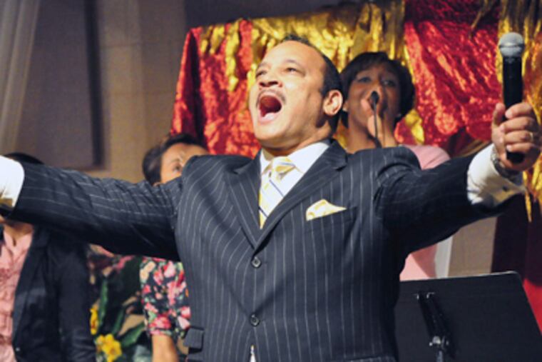 The Rev. Amir Kahn opens the service with a song at Solid Rock church, which he has expanded to host a network of nonprofit institutions. (Gianna Vadino / Staff Photographer)