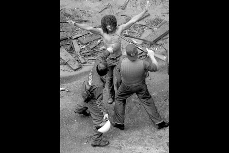 MOVE member Delbert Africa surrenders 8/8/1978 to police after a shoot out at MOVE headquarters in Philadelphia. James G. Domke / Inquirer Staff Photographer