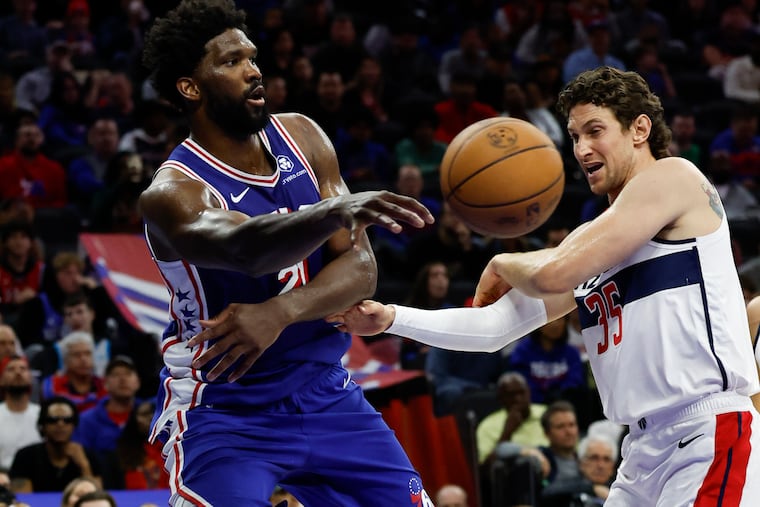 Sixers center Joel Embiid passes the basketball against Washington Wizards center Mike Muscala on Nov. 6.