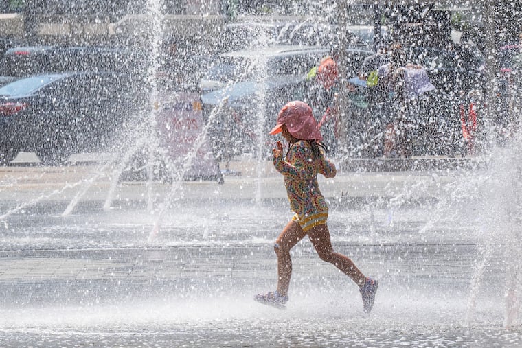 A girl runs through the spray from the fountains at LOVE Park on a day when the temperature topped 100. Get ready for an encore.
