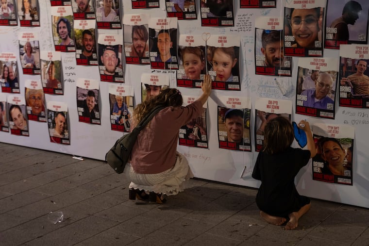 An Israeli woman in Tel Aviv touches photos of Israelis missing and held captive in Gaza. No one should look at the atrocities Hamas committed on Oct. 7 and equivocate or try to justify them, writes Kyle Sammin.