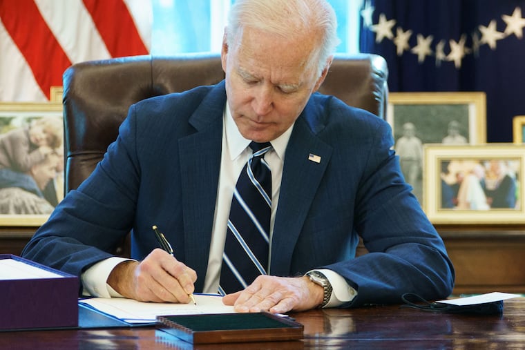 President Joe Biden signs the American Rescue Plan on March 11, 2021, in the Oval Office of the White House.