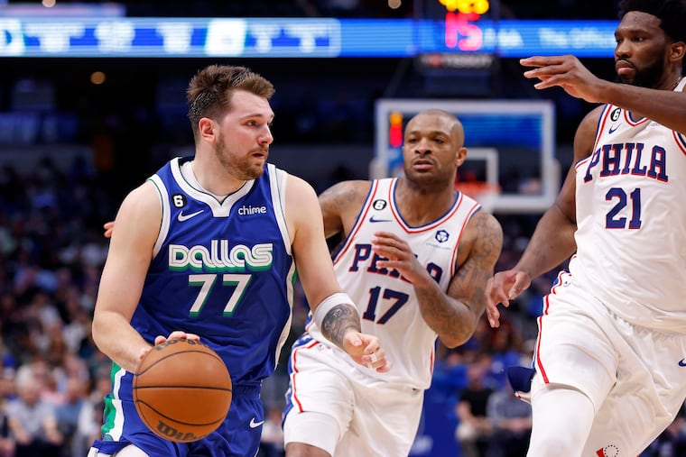 The Dallas Mavericks' Luka Doncic (77) handles the ball as the Philadelphia 76ers' Joel Embiid (21) and P.J. Tucker (17) defend.