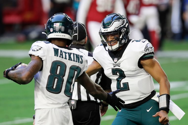 Eagles quarterback Jalen Hurts and wide receiver Quez Watkins celebrate Watkins' second-quarter touchdown against Arizona on Sunday.