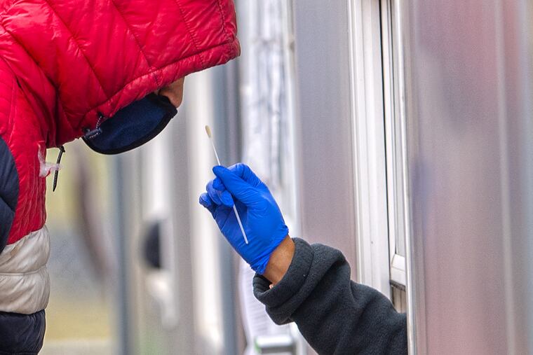 A Sayre Health Center COVID Testing staff, administers a free COVID-19 rapid test inside a trailer on January 5. FEMA will open another mass testing site in Southwest Philadelphia Thursday.