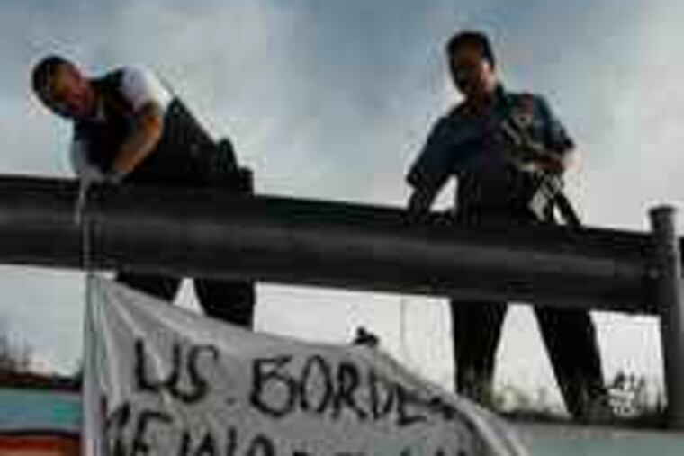 Mexican police bring down a banner hung at the site of the shooting accusing U.S. Border Patrol agents of murder.