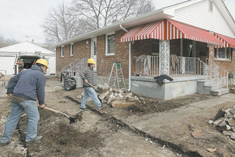 Construction workers renovate a house in Paulsboro, N.J. (Akira Suwa / Staff Photographer)