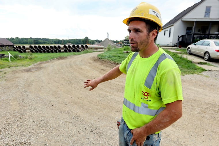 Taylor Purdy, a pipe layer with Complete General Construction, answers questions about his experience working around the new Intel semiconductor manufacturing plant construction site in Johnstown, Ohio, during an interview near the site Friday, Aug. 5, 2022. Purdy spends his days in trenches helping position storm and sanitary sewers and waterlines. Overtime is plentiful as deadlines approach.