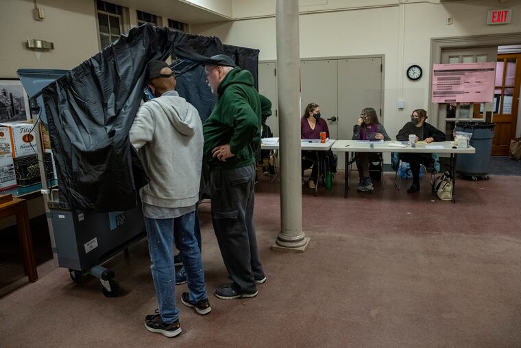 Poll workers prepare a voting machine on Election Day earlier this month at the Falls of Schuylkill branch of the Free Library of Philadelphia. The election was the latest flashpoint in a fight over how Pennsylvania voters' ballots should be cast and counted.