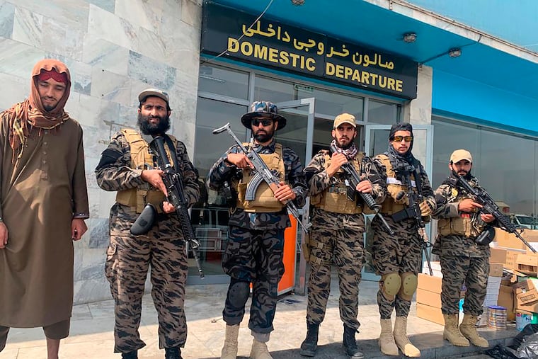 Taliban fighters stand guard Tuesday inside the Hamid Karzai International Airport after the U.S. withdrawal.