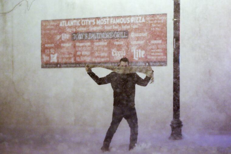 A man struggles to control his scarf in the high winds and blowing snow in Atlantic City on January 4, 2018.