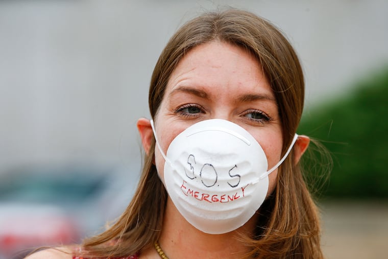 Parent Heather Atkinson wears a mask during a rally before the School District of Philadelphia conducted a town hall meeting discussing the temporarily relocating of Ben Franklin and SLA students while construction is completed on the new shared campus on Monday, October 7, 2019. Atkinson has children at Meredith Elementary School and is flagged by the district as a high-priority school for asbestos removal.