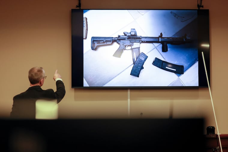 District Attorney Brad Smith, left, points to a weapon that was displayed on the screen during the first day of the trial of Colin Gray, the father of Apalachee High School shooting suspect Colt Gray, in the courtroom at the Barrow County courthouse, Monday, Feb. 16, 2026, in Winder, Ga. (Jason Getz/Atlanta Journal-Constitution via AP)