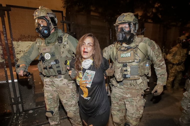A bloodied demonstrator is arrested by federal police during a Black Lives Matter protest at the Mark O. Hatfield United States Courthouse Monday in Portland, Ore.