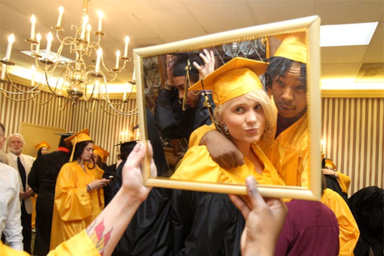 Robyn Lynne Owen, left, and Alicia Ross, right, check their appearance in a mirror before the procession for the graduation ceremony. Friday, June 7, 2013 was graduation day at Lakeside School in North Wales and this class might have more reason than most to celebrate getting diplomas. Lakeside is an alternative, last-chance school for kids who have struggled with truancy, drug problems and other issues.