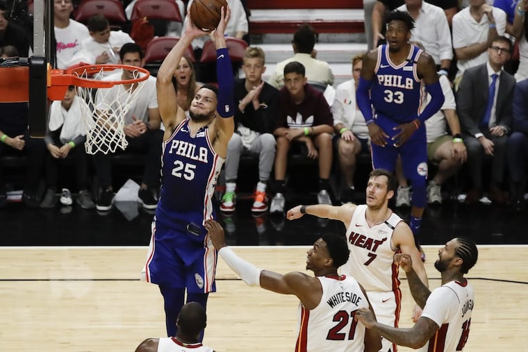 Sixers guard Ben Simmons goes up to dunk the basketball past several Miami Heat players during the Sixers’ game 4 win on Saturday.