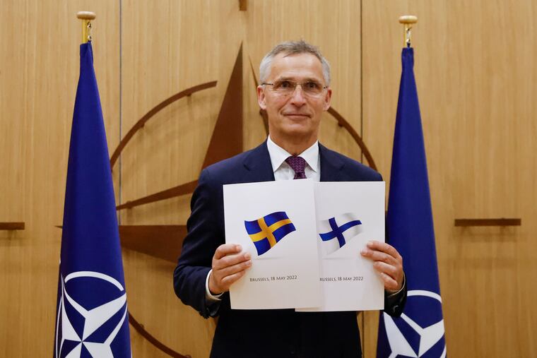 NATO Secretary-General Jens Stoltenberg displays documents Wednesday after Sweden and Finland applied for membership.