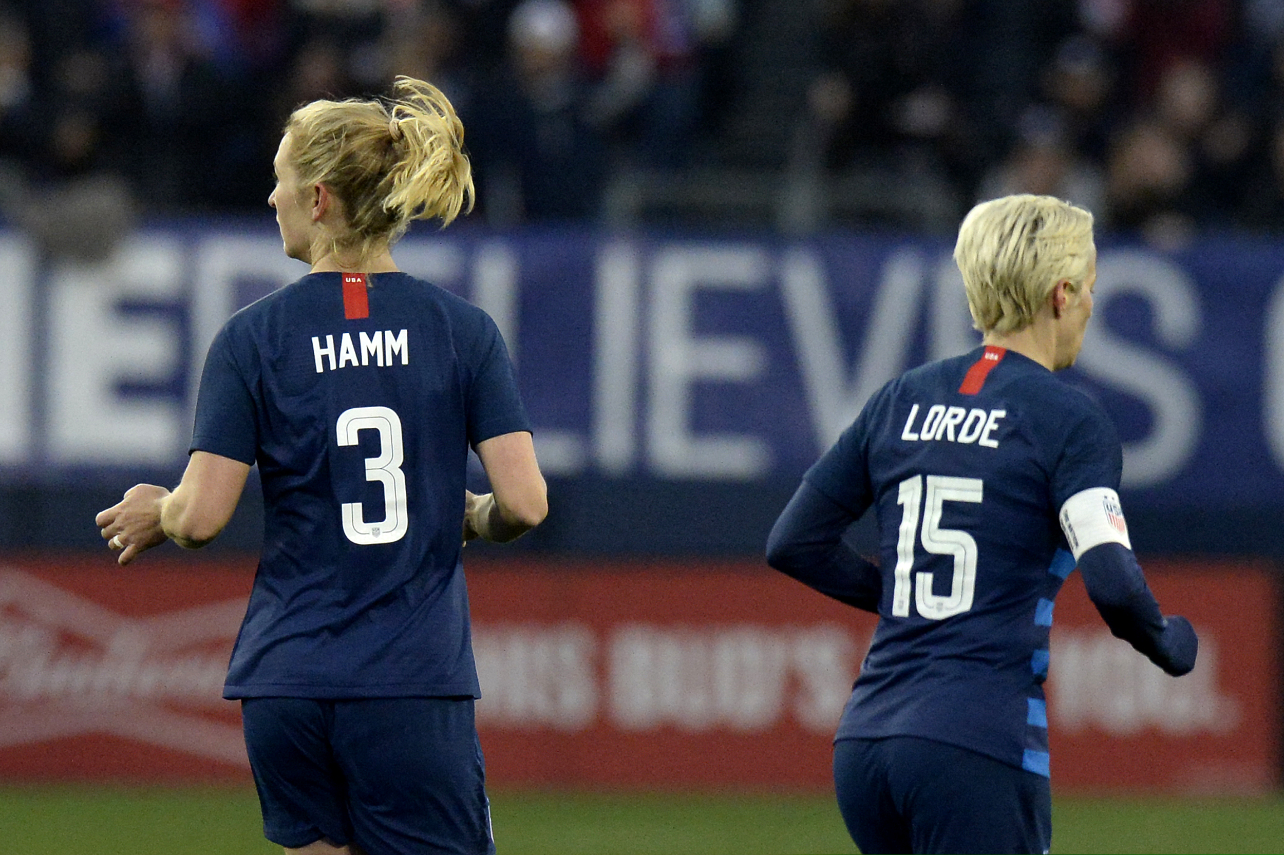 United States midfielder Samantha Mewis (3) and forward Megan Rapinoe (15) play against England during the second half of a SheBelieves Cup women's soccer match Saturday, March 2, 2019, in Nashville, Tenn. Mewis honors Mia Hamm and Rapine honors Audre Lorde by wearing their names on the back of their jerseys.