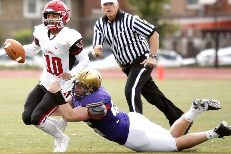 Roman Catholic defensive end Michael Leyland sacks Archbishop Carroll’s Kamal Gray on a fourth-down play in the final quarter Saturday.
