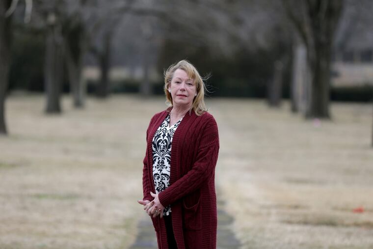 Linda Lacy, cemetery president, poses near the spot where unclaimed bodies are buried in Eglington Cemetery in Clarksboro, NJ. “If you run a cemetery,” she said, “you have to have a big heart.”