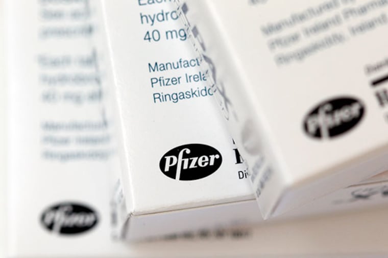 Boxes of the drug Relpax, made by Pfizer, are displayed in Surfside, Fla. Pfizer reports quarterly results before the market open on Tuesday, Oct. 29, 2013. (AP Photo/Wilfredo Lee, File)