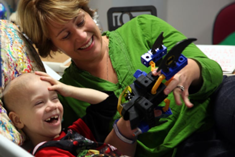Everest Grenke Leach, 5, plays with his mother, Liz Grenke Leach, at Children’s Hospital. He is undergoing immunotherapy as treatment for neuroblastoma. (Laurence Kesterson / Staff Photographer)