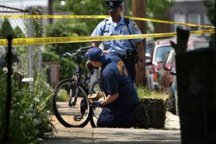 Police dust a bicycle for fingerprints while investigating an alleged home invasion try in Southwest Philly.