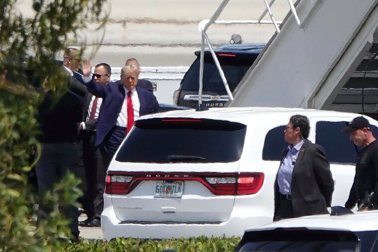 Former president Donald Trump waves before boarding his plane at Palm Beach International Airport on Monday.
