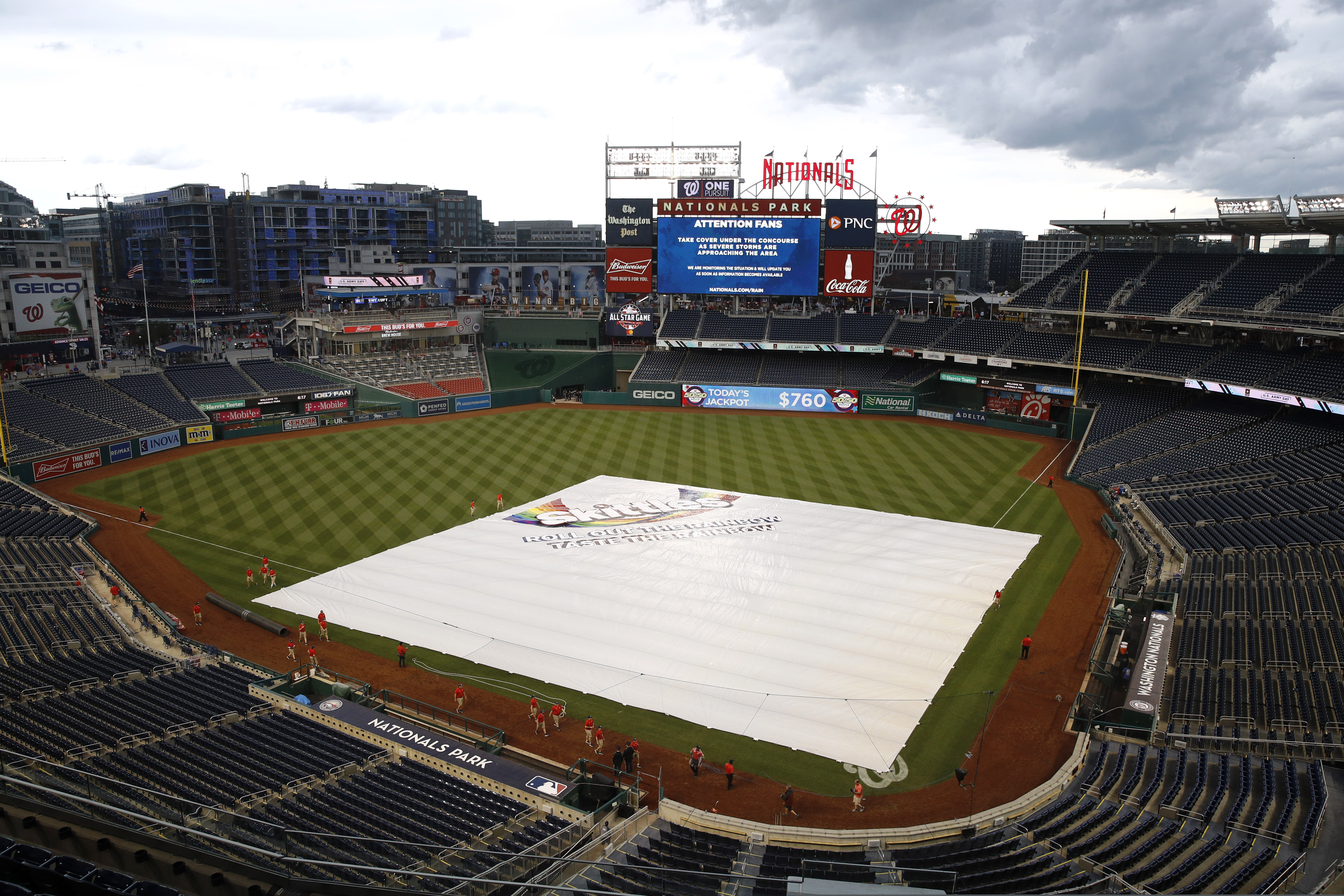 A tarp covers the infield during a rain delay before a baseball game between the Philadelphia Phillies and the Washington Nationals, Tuesday, June 18, 2019, in Washington. (AP Photo/Patrick Semansky)