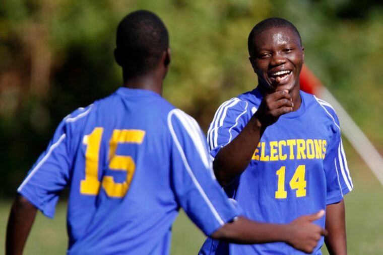 Ben Franklin's Nyuma Koleh, right, celebrates a goal with Sergio Luciano, left, during Franklin's game at Edison in Philadelphia, Pa. on September 24, 2013. Ben Franklin boys' soccer team, which has a large number of international players because its school has a program for immigrant students. ( DAVID MAIALETTI / Staff Photographer )