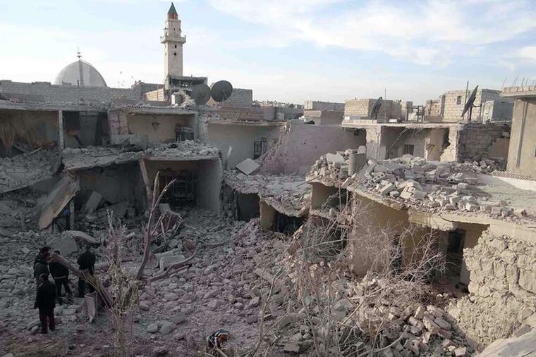 Syrians stand on rubble of houses that were destroyed during air strikes in Aleppo. Planes dumped barrels packed with explosives on at least four opposition-held neighborhoods of Aleppo on Wednesday.