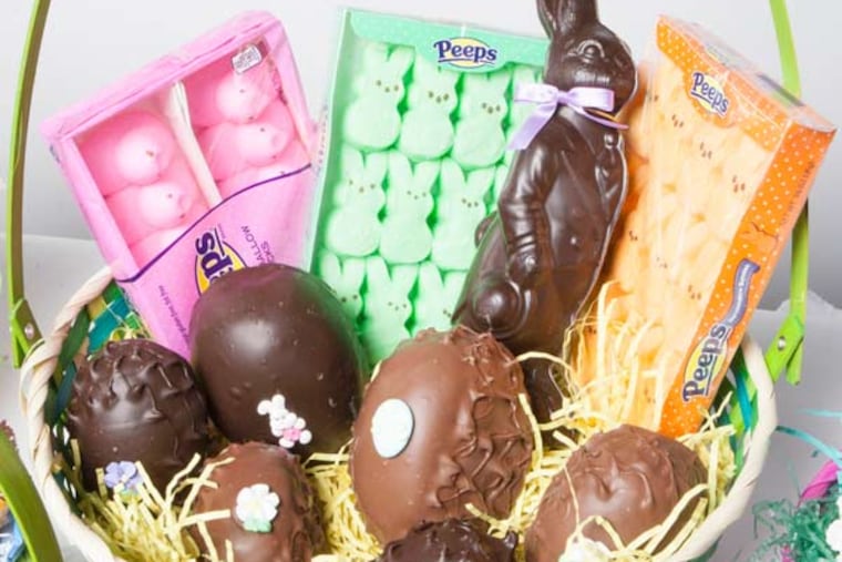 An Easter basket loaded up with chocolate eggs, Peeps, and other candies.