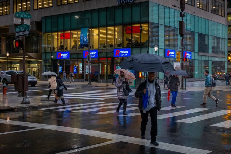 Pedestrians at 16th and Market Street on a cold and rainy morning in Center City Philadelphia on Thursday.